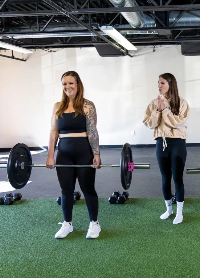 Group strength training class practicing deadlift form