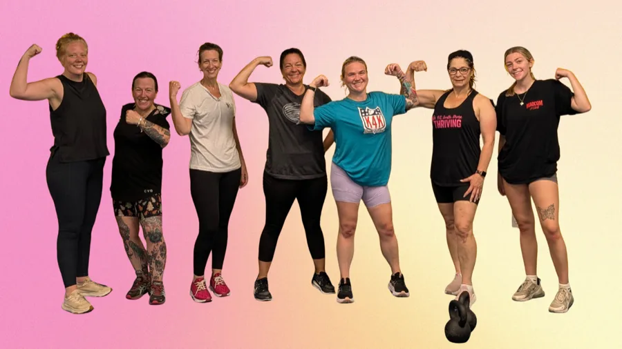Group of Barbell Boutique clients flexing and smiling together